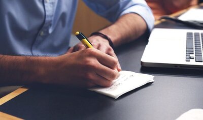 4 Tips for Training Your Redemption Counter Staff - Man Writing at Desk